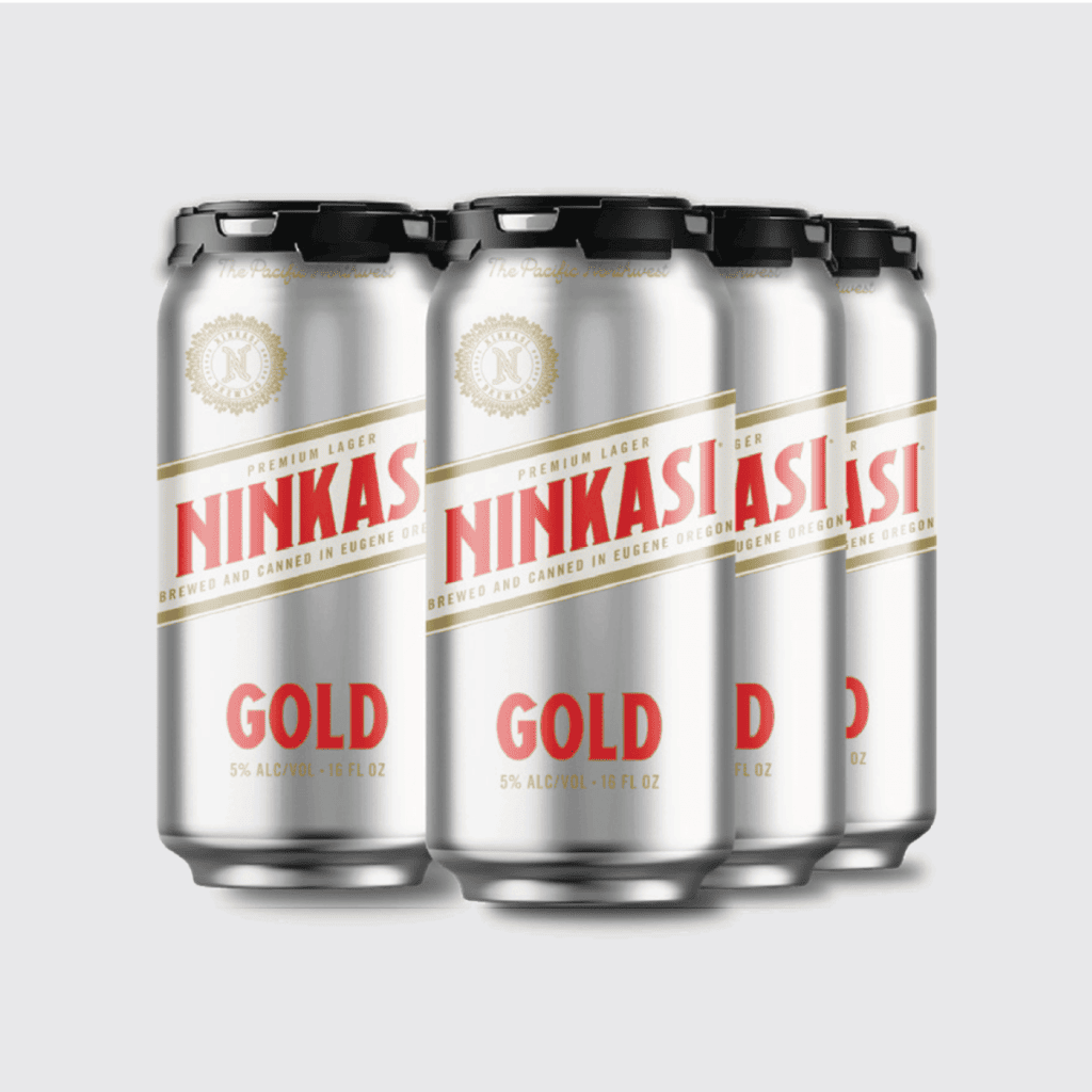 The image displays a six-pack of Ninkasi Gold Premium Lager cans. The cans are silver with the "Ninkasi" name and logo in large, prominent red letters with a gold outline. Below the logo, "GOLD" is written in bold gold letters. Above the logo, "PREMIUM LAGER" is stated in smaller print, and there is a seal with the letter "N" in the center symbolizing the brand. Each can specifies that it contains "5% ALC/VOL - 16 FL OZ" indicating the alcohol content and volume of the beer. The cans are topped with black plastic holders, and the text "The Pacific Northwest" and "Brewed and Canned in Eugene, Oregon" highlights the regional provenance of the beer. The design is clean and modern with a color scheme that conveys a premium quality product.